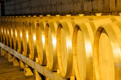 Wine barrels stacked in the cellar Stock Photos
