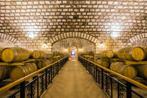 Wine barrels stacked in the cellar Stock Photos