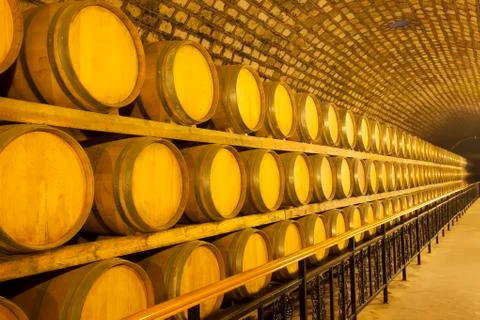 Wine barrels stacked in the cellar Stock Photos