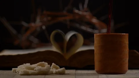 Wine being Poured beside Bread with Bible and Thorn Crown in Background Video stock 128593405