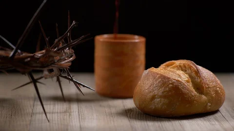 Wine being poured into cup with Bread and Thorn Crown beside. Wine Stock Footage 128553686