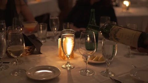 Wine being poured at a large round, well decorated table in a fine dining Stock Footage 93817452