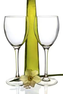 Wine bottle and two empty glasses with daffodil against a white background Stock Photos