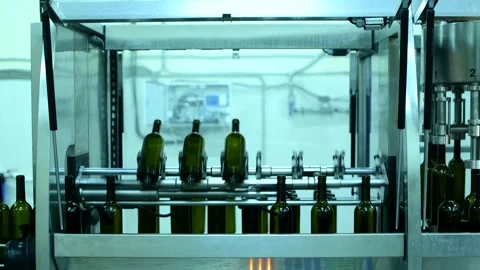 Wine bottle conveyor system in action at a busy factory producing red and white Stock Footage 323783380