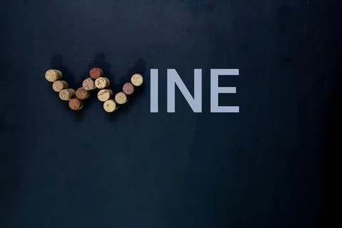 Wine bottle corks completing the word WINE on black background Stock Photos