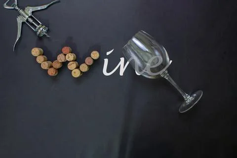 Wine bottle corks completing the word WINE on black background with pull cork Photos