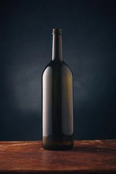 Wine bottle without label, no brand mockup on dark wooden background. Alcohol Stock Photos
