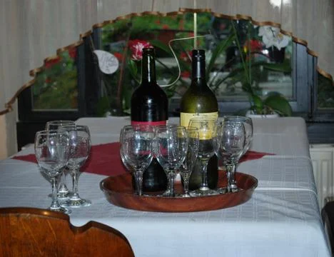Wine bottles and jars on table Stock Photos