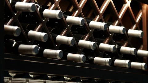 Wine bottles pan down to hanging wine glasses 스톡 동영상 108363350