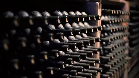 Wine bottles stacked in a cellar with shallow depth of field Stock Footage 71422970