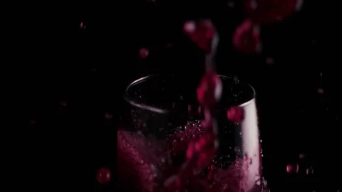 Wine is falling into a glass of red wine with splashes Stock Footage 74877074