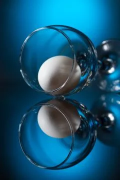 Wine glass with egg lying on table Stock Photos