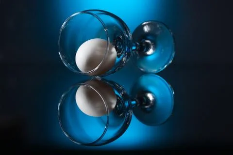 Wine glass with egg lying on table Stock Photos