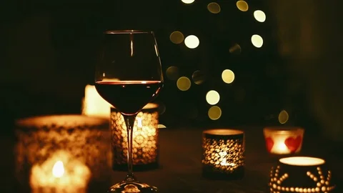 Wine glass sits on a table on the background of flickering lights Video stock 97614477