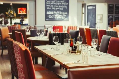 Wine glasses and silverware on table in empty restaurant Foto stock