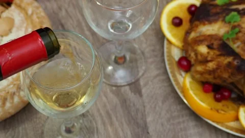 Wine glasses in front of chicken dinner, pour wine Thanksgiving  Christmas Stock Footage 257599583