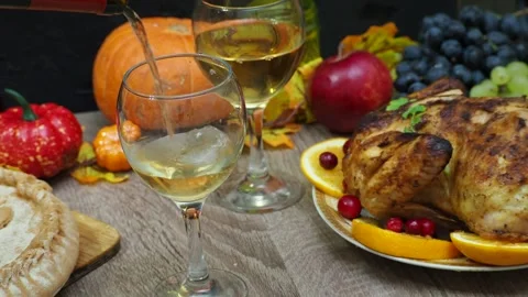Wine glasses in front of chicken dinner, pour wine Thanksgiving  Christmas Stock Footage 257599618