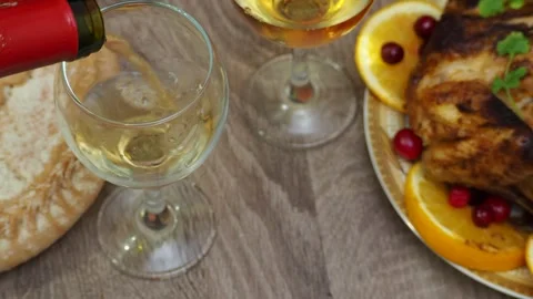 Wine glasses in front of chicken dinner, pour wine Thanksgiving  Christmas Stock Footage 257599649