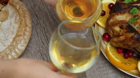 Wine glasses in front of chicken dinner, pour wine Thanksgiving  Christmas Stock Footage 257599651