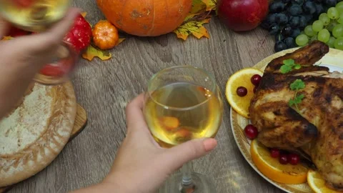 Wine glasses in front of chicken dinner, pour wine Thanksgiving  Christmas Stock Footage 257601063