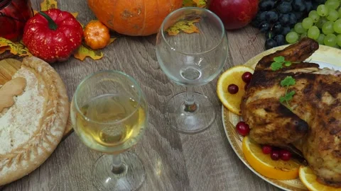Wine glasses in front of chicken dinner, pour wine Thanksgiving  Christmas Stock Footage 257601624