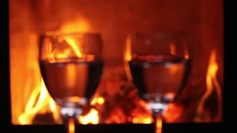 Wine glasses in front of fireplace - close up Video stock 181655725
