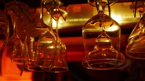 Wine glasses hanging upside down from bar ceiling rack 库存影片 334790308