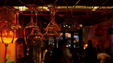 Wine glasses hanging upside down from bar ceiling rack Видео 334790313
