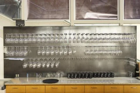 Wine glasses hanging upside down in modern bar, ready for happy hour Foto stock