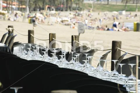 Wine Glasses Set Upside Down In Rows On Table At Seaside Restaurant