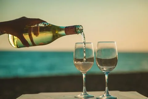 Wine glasses at sunset on the beach. Selective focus. Stock Photos