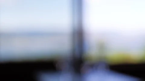 Wine glasses on table by window with beautiful view of lake, mountains in view Video stock 122590998