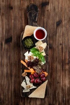 Wine platter with assorted snacks such as grissini, cheese, sliced meat and n Stock Photos