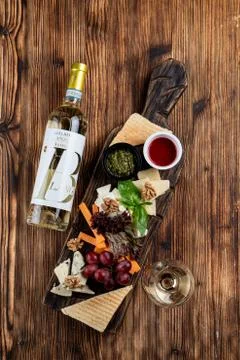 Wine platter with assorted snacks such as grissini, cheese, sliced meat and n Stock Photos