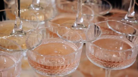 The wine is poured into glasses on the table. Beautiful pink color of the drink Stock Footage 321945412