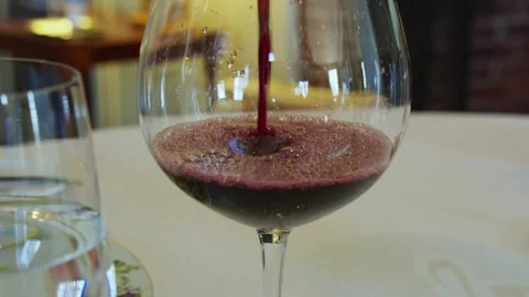 Wine pouring at dinner table at a restaurant. White table cloth Stock Footage 344192179
