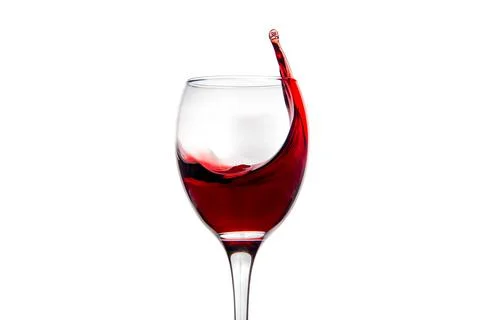 Wineglass with splashing drops of red wine Stock Photos