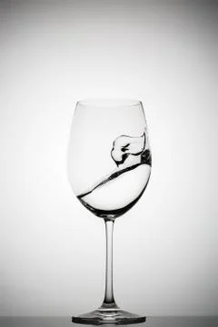 Wineglass with splashing liquid Фото