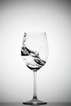 Wineglass with splashing liquid Stock Photos