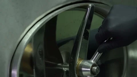 Winemaker closes the door of the stainless steel wine tank. 库存影片 134605274