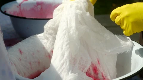 Winemaker filtering cherry juice through cheesecloth Stock-Footage 314891273