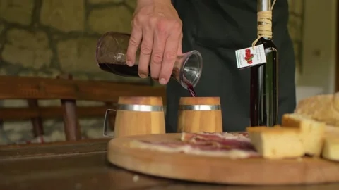 A winemaker serves a glass of red wine in a typical inn, in Bosnia Stock Footage 243847015