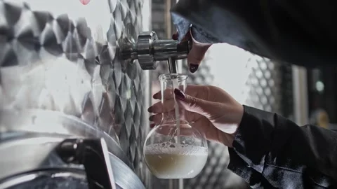 Winery chemist takes a sample of wine must into a glass flask. Stock Footage 270057957