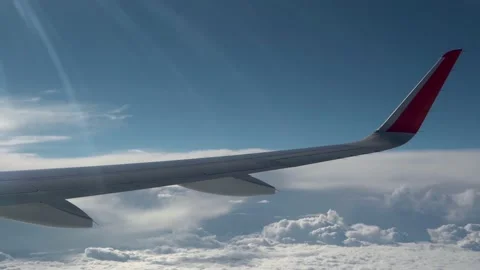 Wing of aircraft flies over clouds. Sun rays on wing. Small clouds fly fast Stock Footage 236506343