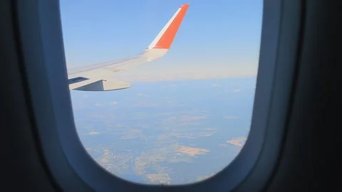 Wing of aircraft in the window. wing of the plane flies over the clouds in the Stock Footage 180889692