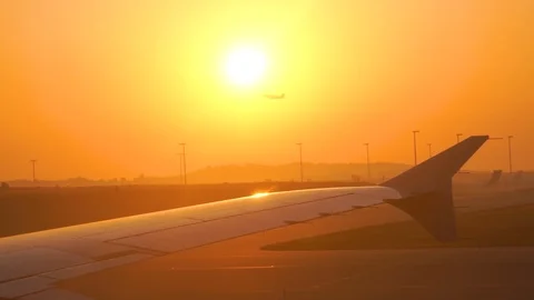 Wing of an airplane above clouds in sunset light. Golden background. Video stock 103547334