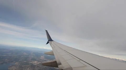 Wing of an airplane in the air. Plane ascending from the SEA airport with Stock Footage
