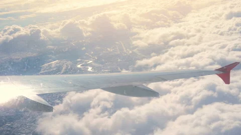 Wing airplane and cloud on sky. View through an airplane window. City in cloud. Video stock 89772158