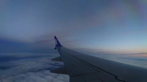 The wing of an airplane in the clouds at sunset. view from the window. Stock Footage 242892380