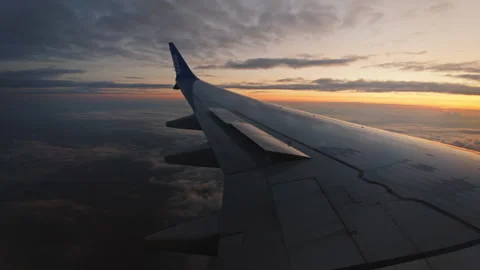 The wing of an airplane in the clouds at sunset. view from the window. Stock Footage 242892421
